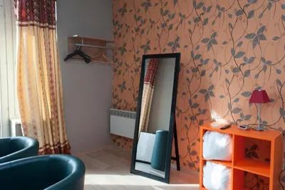a room with a mirror and a blue chair at Hotel Castel in Ghent