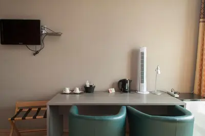 a table with two blue chairs in a room at Hotel Castel in Ghent