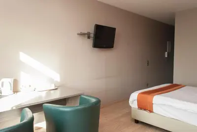 a room with a bed and a desk with two chairs at Hotel Castel in Ghent