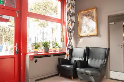 two chairs in a waiting room with a window at Hotel Castel in Ghent