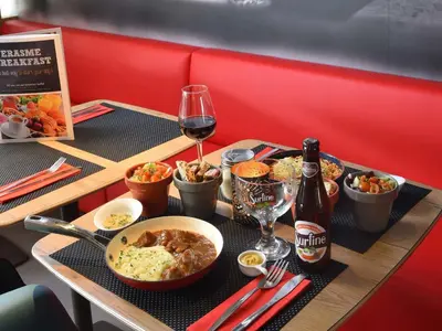 a table with a tray of food and a bottle of wine at Ibis Brussels Erasmus in Brussels