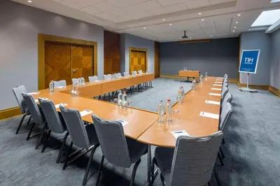 a large conference room with a long table and chairs at NH Brussels Airport in Diegem