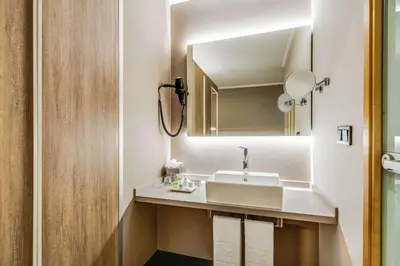 a bathroom with a sink and a mirror at NH Brussels Airport in Diegem