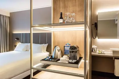 a hotel room with a bed and a coffee maker at NH Brussels Airport in Diegem