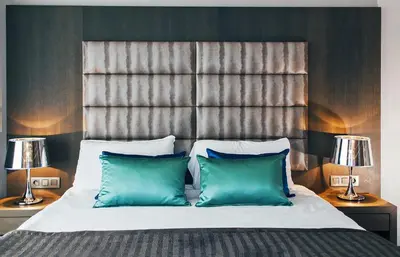 a bedroom with a large bed with green pillows at Hotel Agenda Louise in Brussels