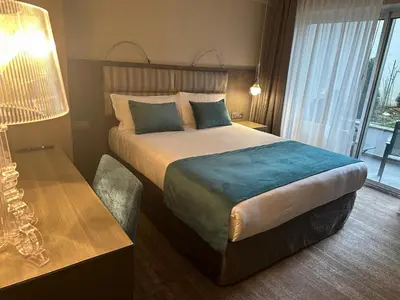 a hotel room with a large bed and a desk at Hotel Agenda Louise in Brussels
