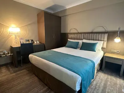 a hotel room with a large bed with blue pillows at Hotel Agenda Louise in Brussels