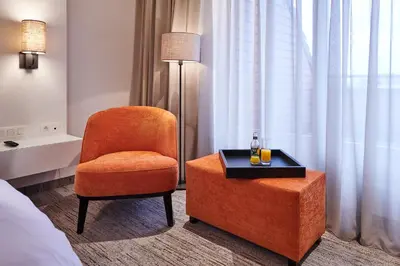 a room with a chair and a table and a lamp at Keizershof Hotel Aalst in Aalst