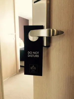 a door with a do not disturb sign on it at Axis Hotel in Kortenberg