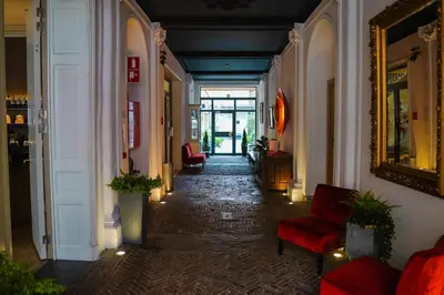 a hallway with chairs and a mirror in a building at Hotel de Flandre Ghent in Ghent