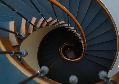 a spiral staircase with a person in the middle at Hotel de Flandre Ghent in Ghent