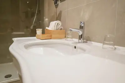 a bathroom sink with a faucet and a towel at Hotel de Flandre Ghent in Ghent