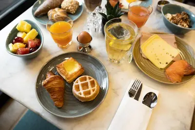 a table topped with plates of breakfast foods and drinks at Holiday Inn Brussels Schuman by IHG in Brussels