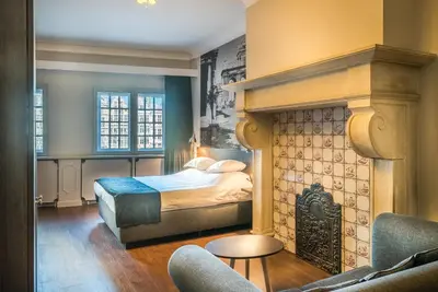 a bedroom with a bed and a fireplace at Résidence-Hotel Le Quinze Grand Place Brussels in Brussels