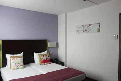 a bedroom with a large bed with purple walls at Hotel Floris Arlequin Grand-Place in Brussels