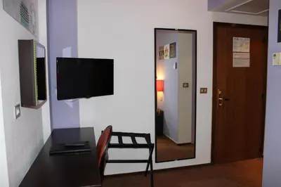 a room with a desk and a television and a door at Hotel Floris Arlequin Grand-Place in Brussels