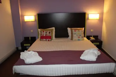 a bedroom with a large bed with towels on it at Hotel Floris Arlequin Grand-Place in Brussels