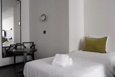 a room with a bed and a table with a mirror at Hotel Floris Arlequin Grand-Place in Brussels