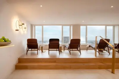 a waiting room with chairs and a table and windows at The Hotel Brussels in Brussels