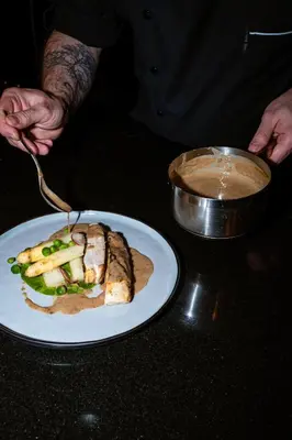 a person eating a plate of food on a table at The Hotel Brussels in Brussels