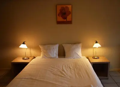 a bedroom with a white bed with two lamps at Condo Gardens Antwerp in Antwerp