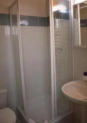 a bathroom with a shower and a toilet and a sink at Condo Gardens Antwerp in Antwerp