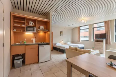 a room with a kitchen and a living room at Condo Gardens Brussels in Brussels