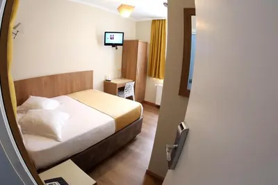 a hotel room with a bed and a television at Sun Hotel in Brussels