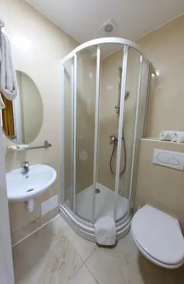 a bathroom with a shower and a toilet and a sink at Sun Hotel in Brussels
