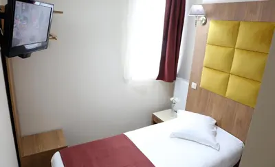 a small room with a bed and a television at Sun Hotel in Brussels