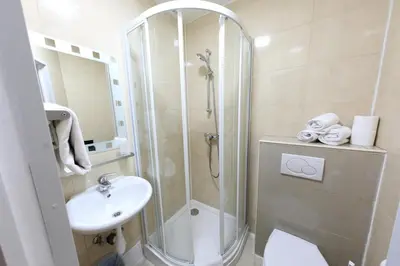 a bathroom with a shower and a toilet and a sink at Sun Hotel in Brussels