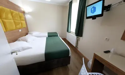 a bedroom with a bed with a tv on the wall at Sun Hotel in Brussels
