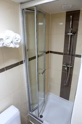 a shower with a glass door next to a toilet at Sun Hotel in Brussels