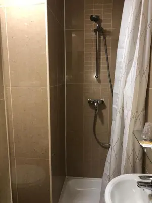 a bathroom with a shower and a sink at Sun Hotel in Brussels