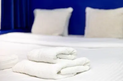 two white towels are stacked on a bed at P6 Antwerp in Antwerp