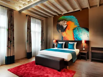 a bedroom with a painting of a parrot on the wall at Hotel Harmony in Ghent