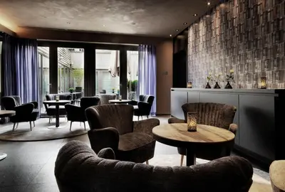 a restaurant with chairs and tables and a table and chairs at Hotel Harmony in Ghent