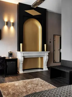 a living room with a fireplace and a gold wall at Hotel Harmony in Ghent