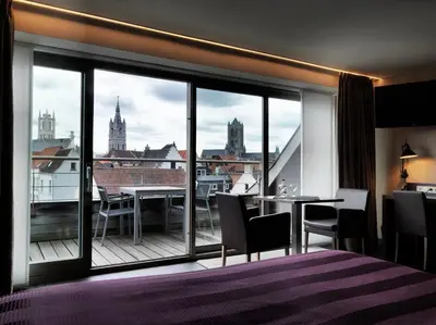 a hotel room with a balcony with a view of the city at Hotel Harmony in Ghent
