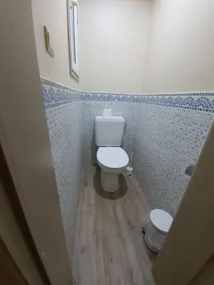 a bathroom with a toilet and a blue tiled wall at Hotel Midi-Zuid in Brussels