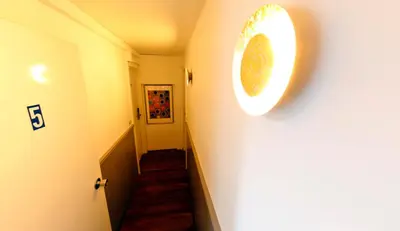 a hallway with a stairway with a clock on the wall at Hotel Midi-Zuid in Brussels