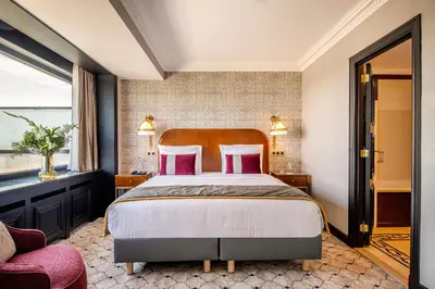a bedroom with a large bed with pink pillows at Hotel Barsey by Warwick in Brussels