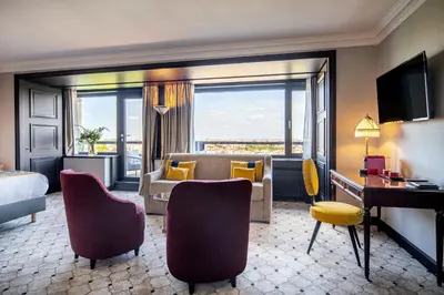 a hotel room with a bed and a desk and a couch at Hotel Barsey by Warwick in Brussels