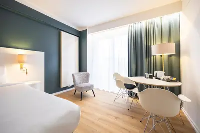 a hotel room with a bed and a table and chairs at Hotel Louise in Brussels