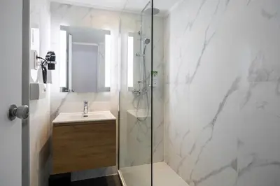 a bathroom with a shower and a sink at Hotel Louise in Brussels