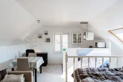a living room with a dining table and a kitchen at Studio Apartment Alba in La Hulpe