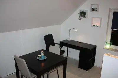 a dining room with a table and a desk at Studio Apartment Alba in La Hulpe