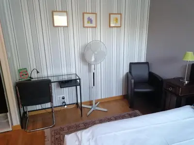a living room with a couch and a chair and a fan at Hotel Prins van Oranje in Diest