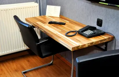 a desk with a phone and a remote control on it at Hotel Prins van Oranje in Diest