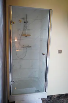 a shower with a glass door in a bathroom at Hotel Prins van Oranje in Diest